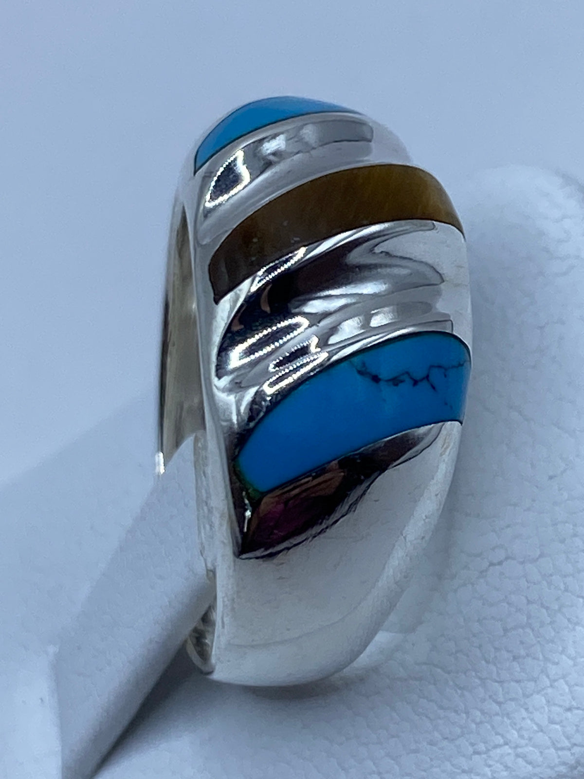 Anillo puesto en la mano mostrando el diseño geométrico con turquesa azul
