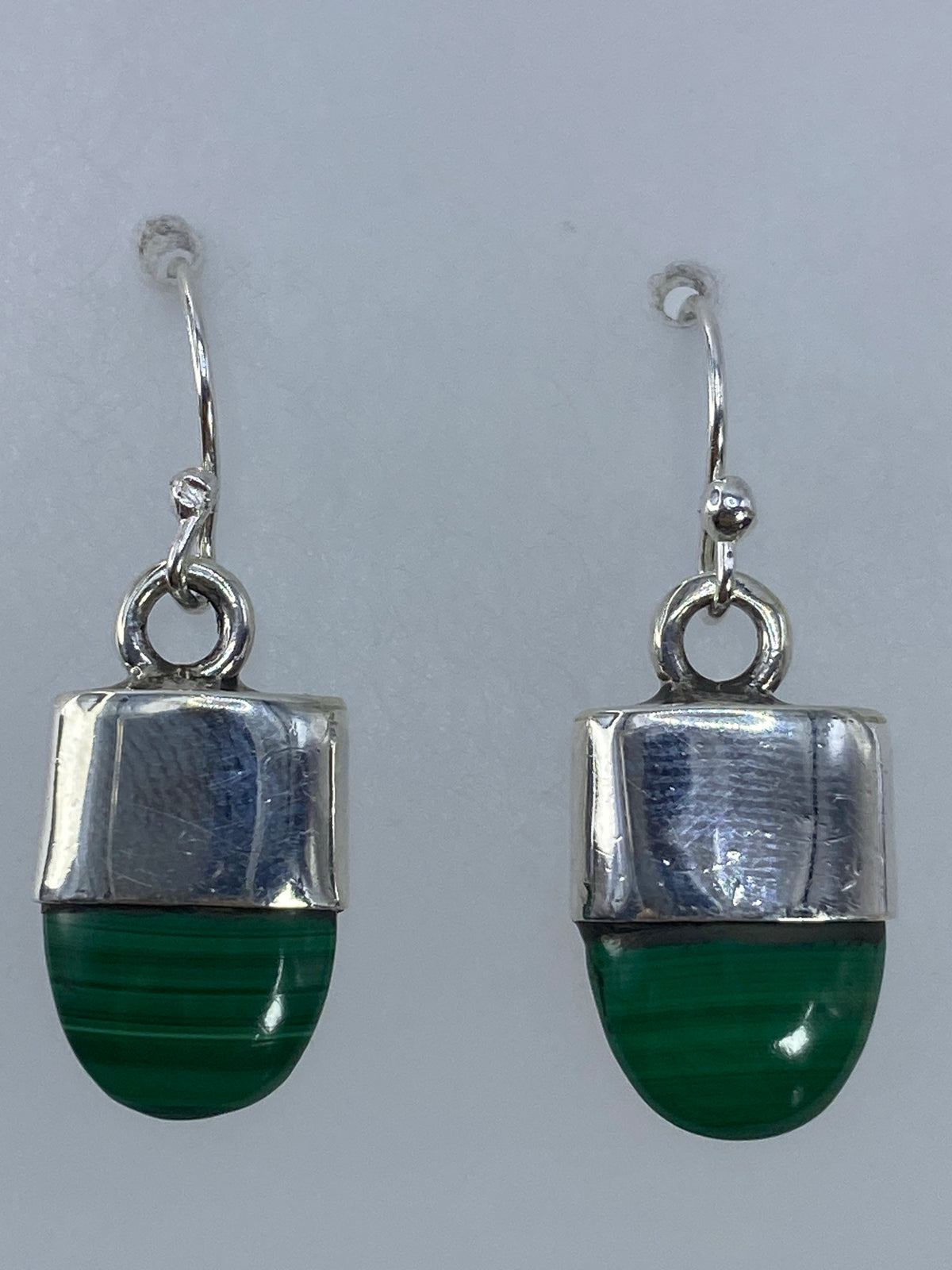 Aretes de malaquita colgando del gancho de plata, mostrando proporción de 3 cm