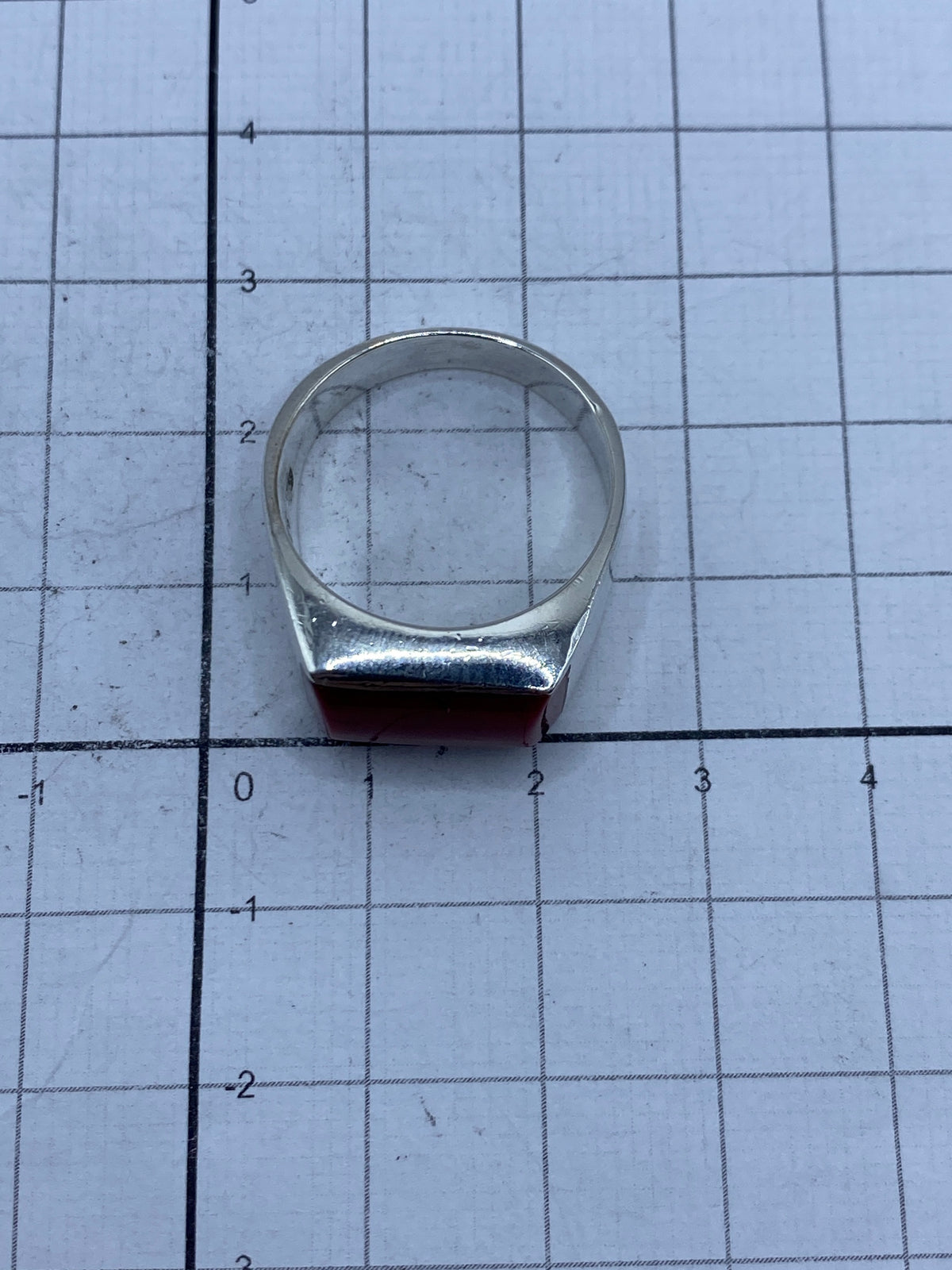 Anillo de plata con coral rojo puesto en la mano