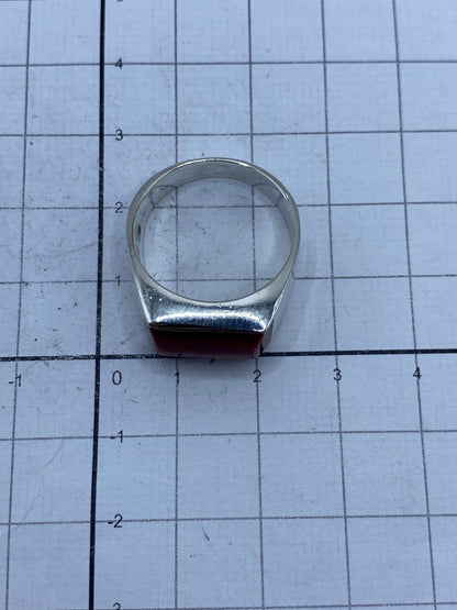 Anillo de plata con coral rojo puesto en la mano