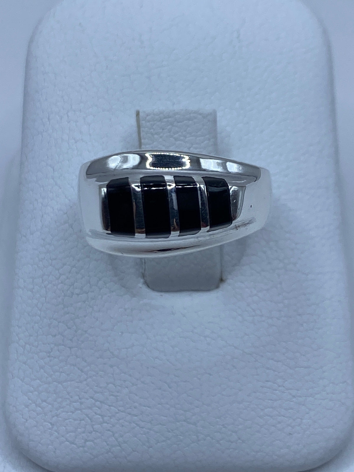 Anillo de plata masivo con ónix negro en dedos de hombre, vista frontal