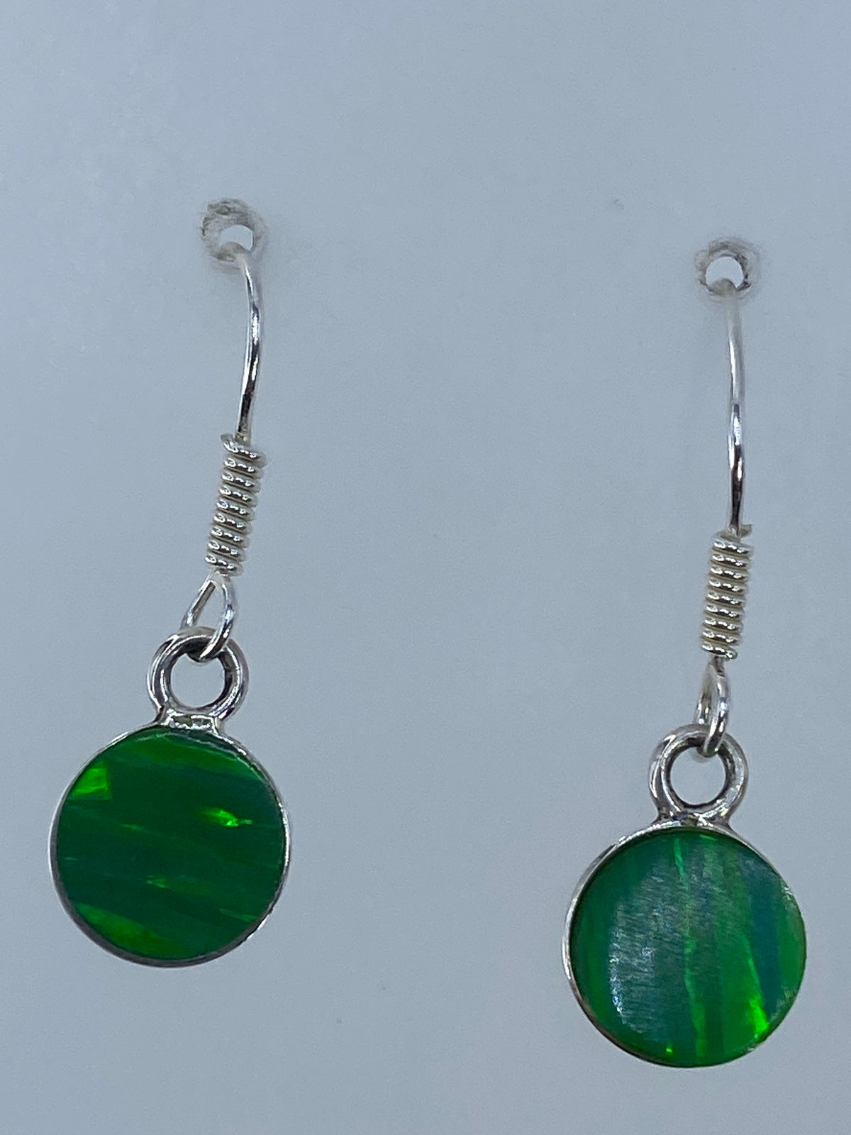 Aretes sobre regla de centímetros mostrando 2.4 cm de largo