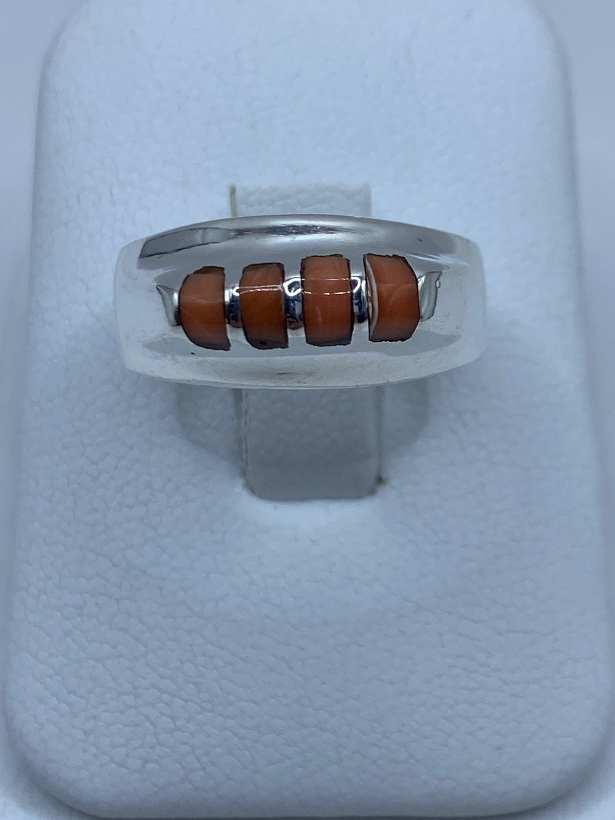 Anillo de plata con cuatro incrustaciones de coral engastadas a mano, visto de frente