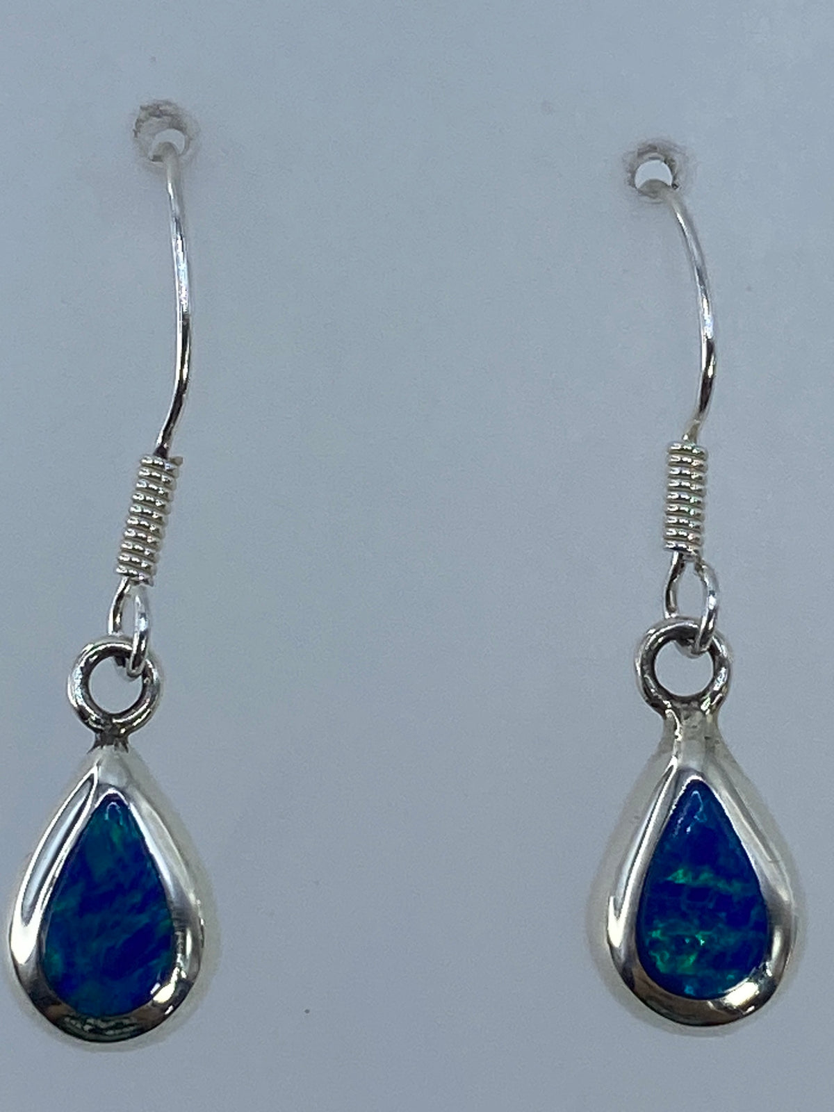 Aretes medidos en regla mostrando largo de 3.2 cm