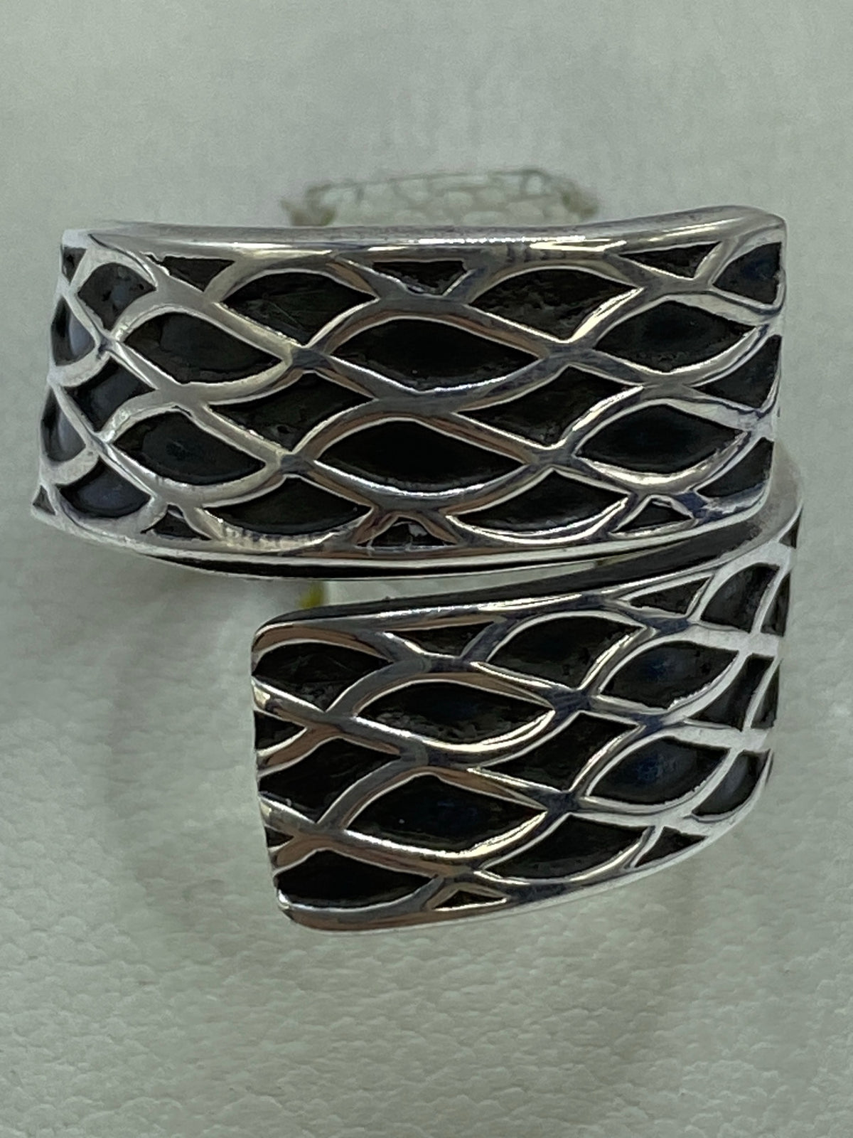 Anillo de plata repujado con patrón de escamas geométricas en relieve, visto de frente