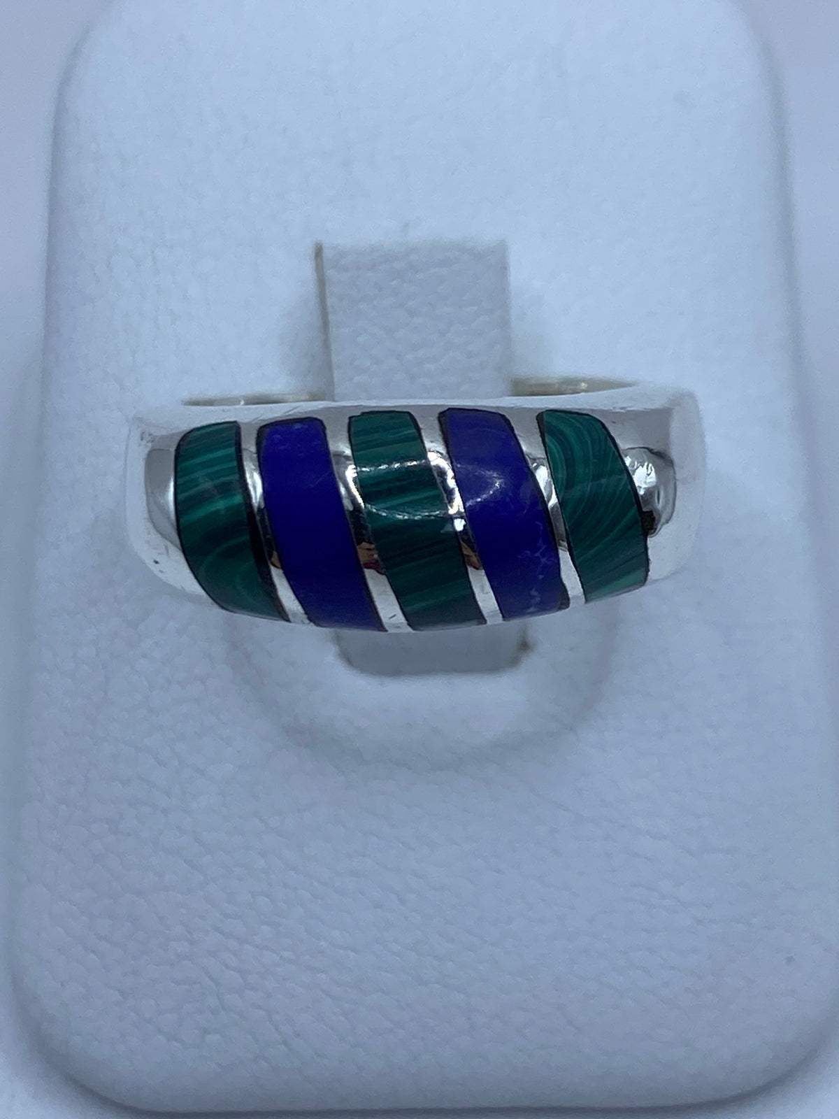 Anillo de plata 925 con malaquita verde engastada en patrón de cinco piedras en la mano