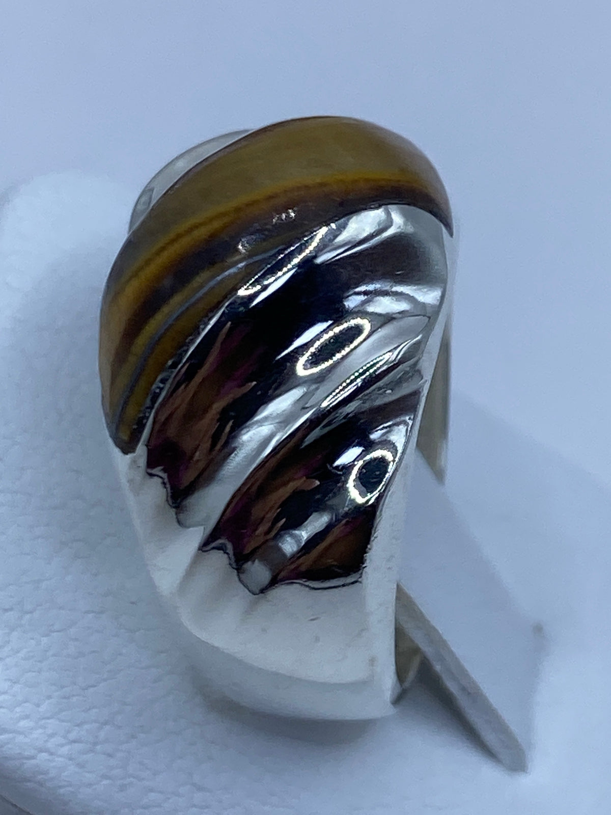 Ojo de Tigre café engastado a mano en plata, reflejo luminoso
