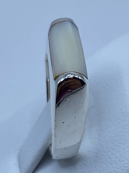 Anillo puesto en dedo, luciendo la perla con luster nacarado