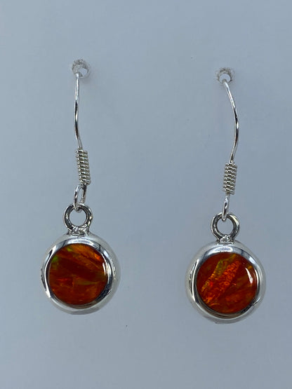 Detalle del engaste de ópalo de fuego en cilindro de plata, mostrando el brillo naranja y reflejos dorados