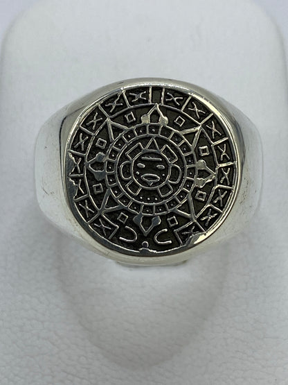 Anillo de plata repujado con Calendario Azteca en la mano, mostrando el relieve del sol central