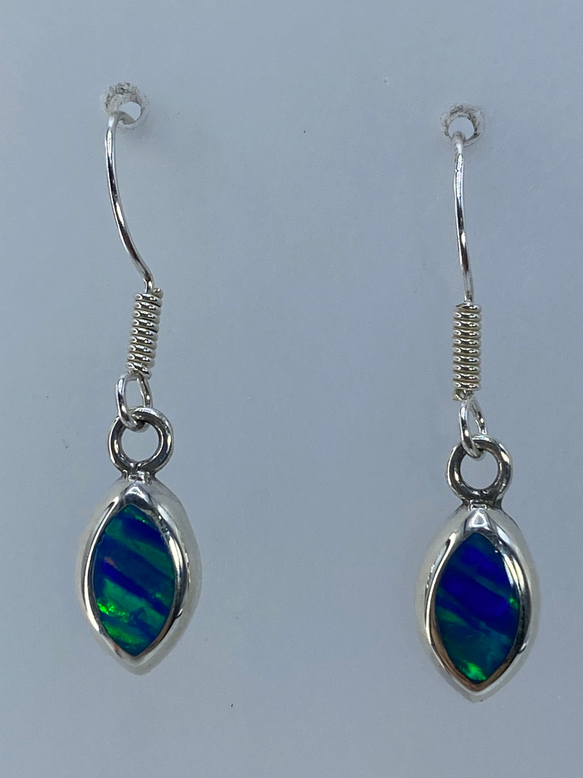Par de aretes de plata 950 con ópalo de fuego verde olivo, colgando en detalle
