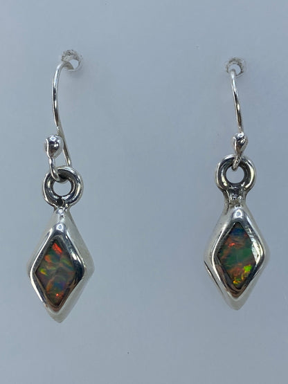 Par de aretes de plata con ópalo de fuego multicolor mostrando destellos rojos y verdes
