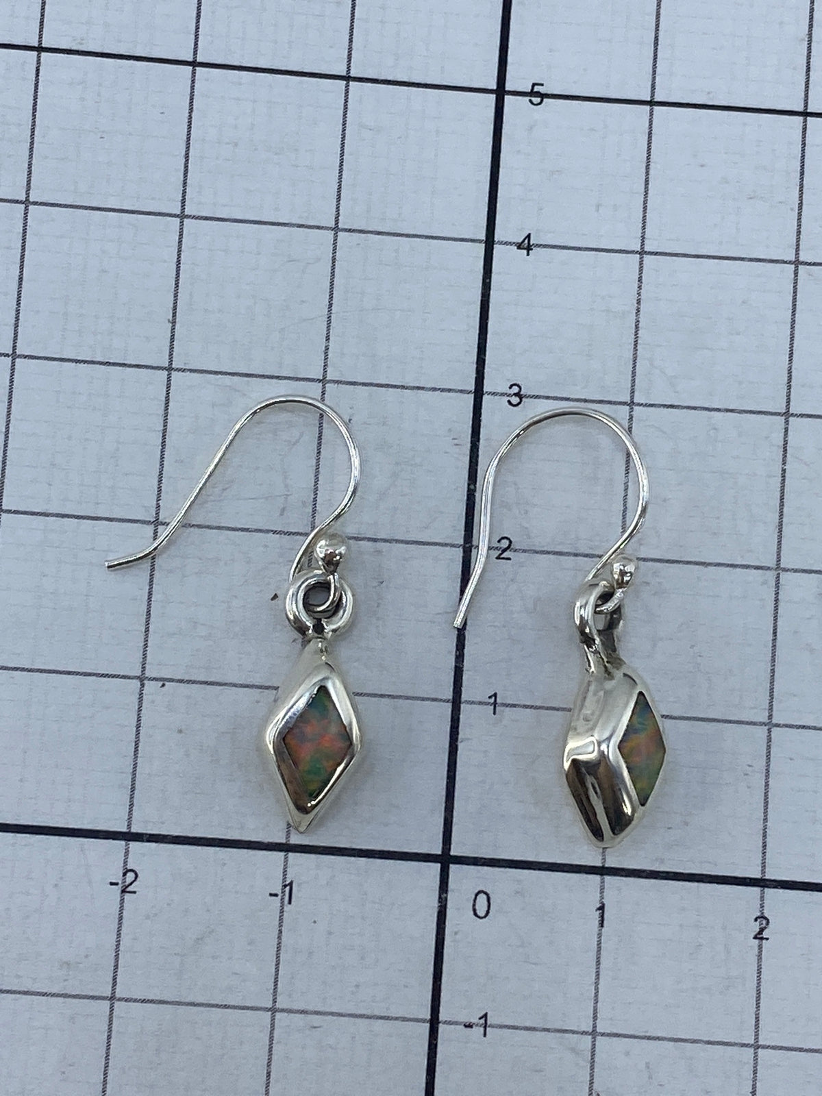 Aretes de plata taxqueña con piedra de ópalo en estuche, Quinto visible en la base