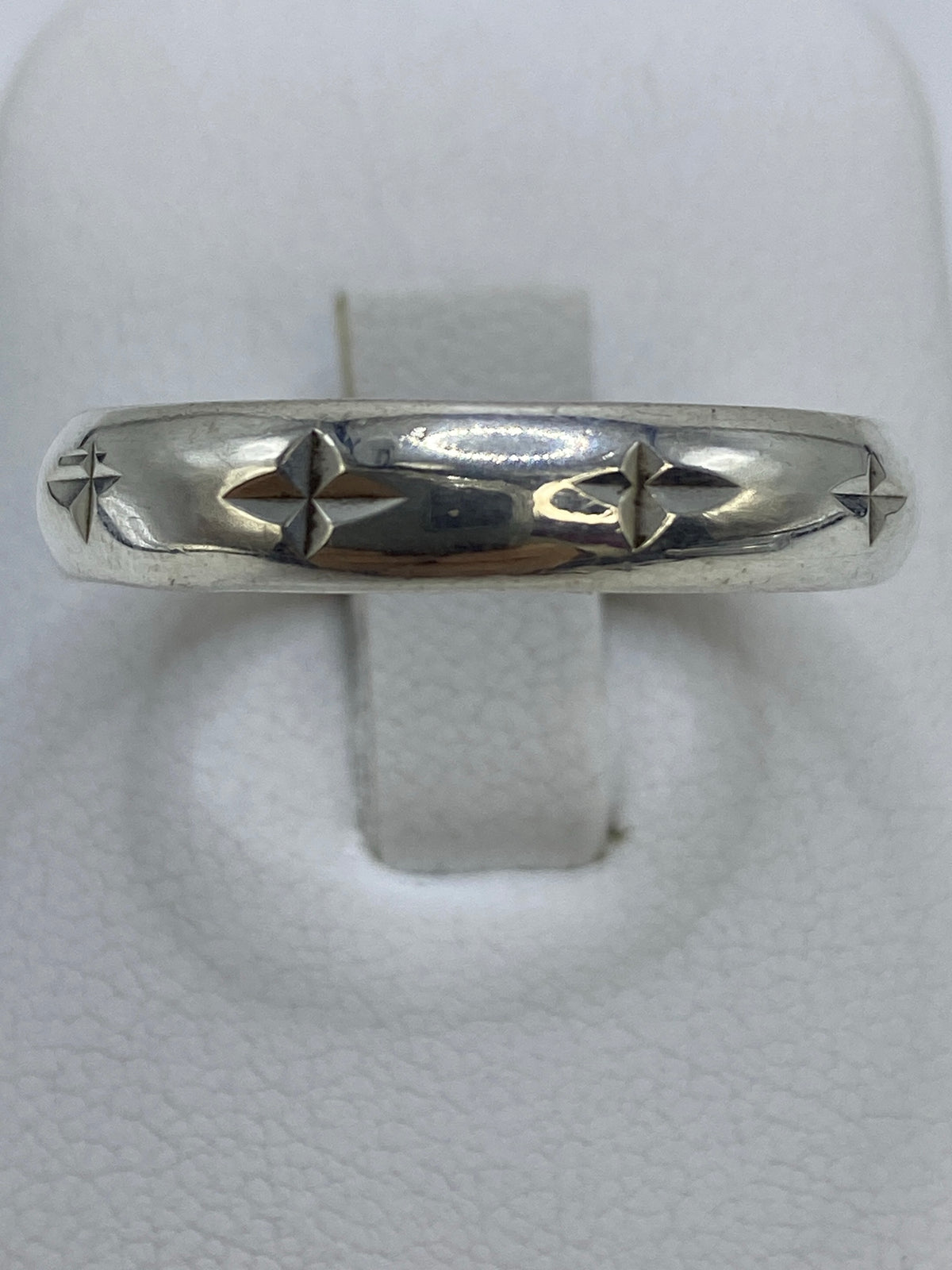 Anillo de plata repujado talla 12 en mano de mujer, vista frontal del diseño pulido