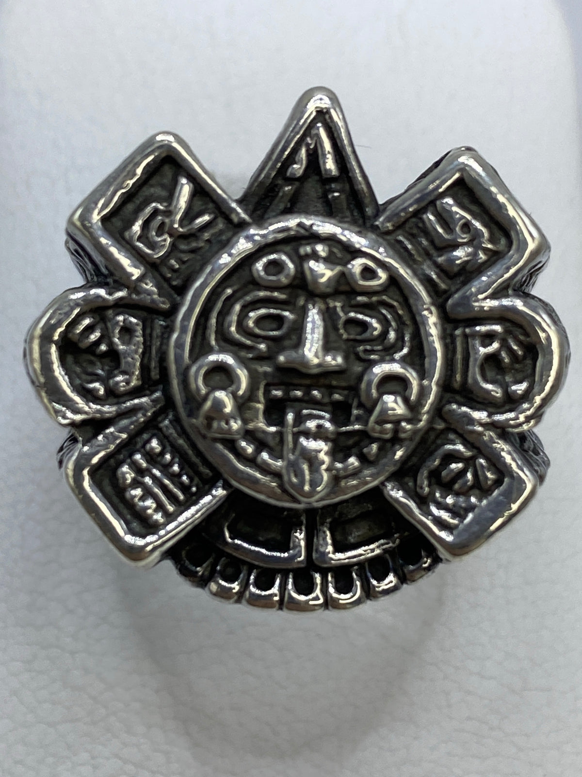 Anillo de plata repujado con Calendario Azteca en la mano de un hombre