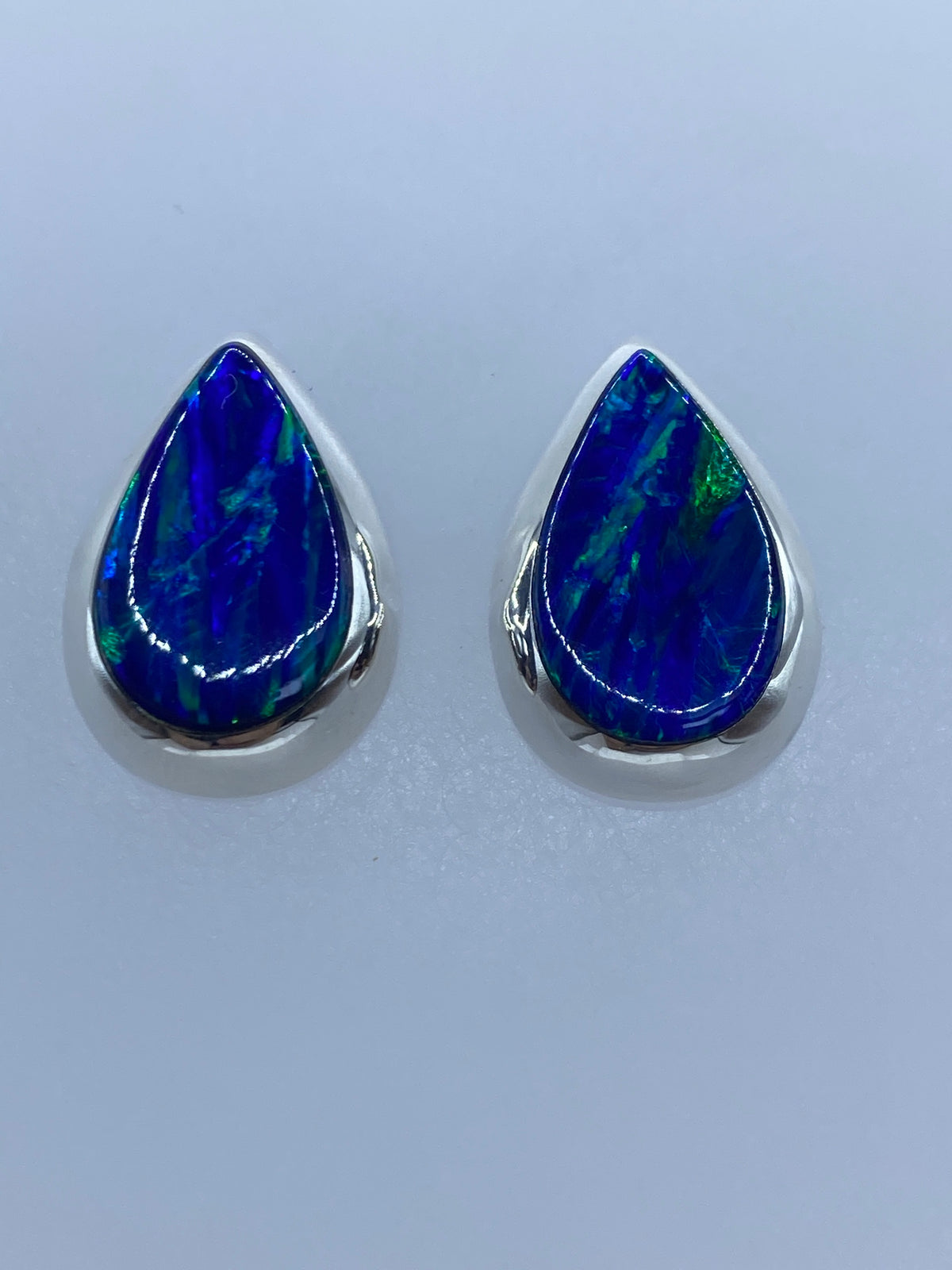 Vista lateral de los aretes de ópalo azul en engaste de plata 925