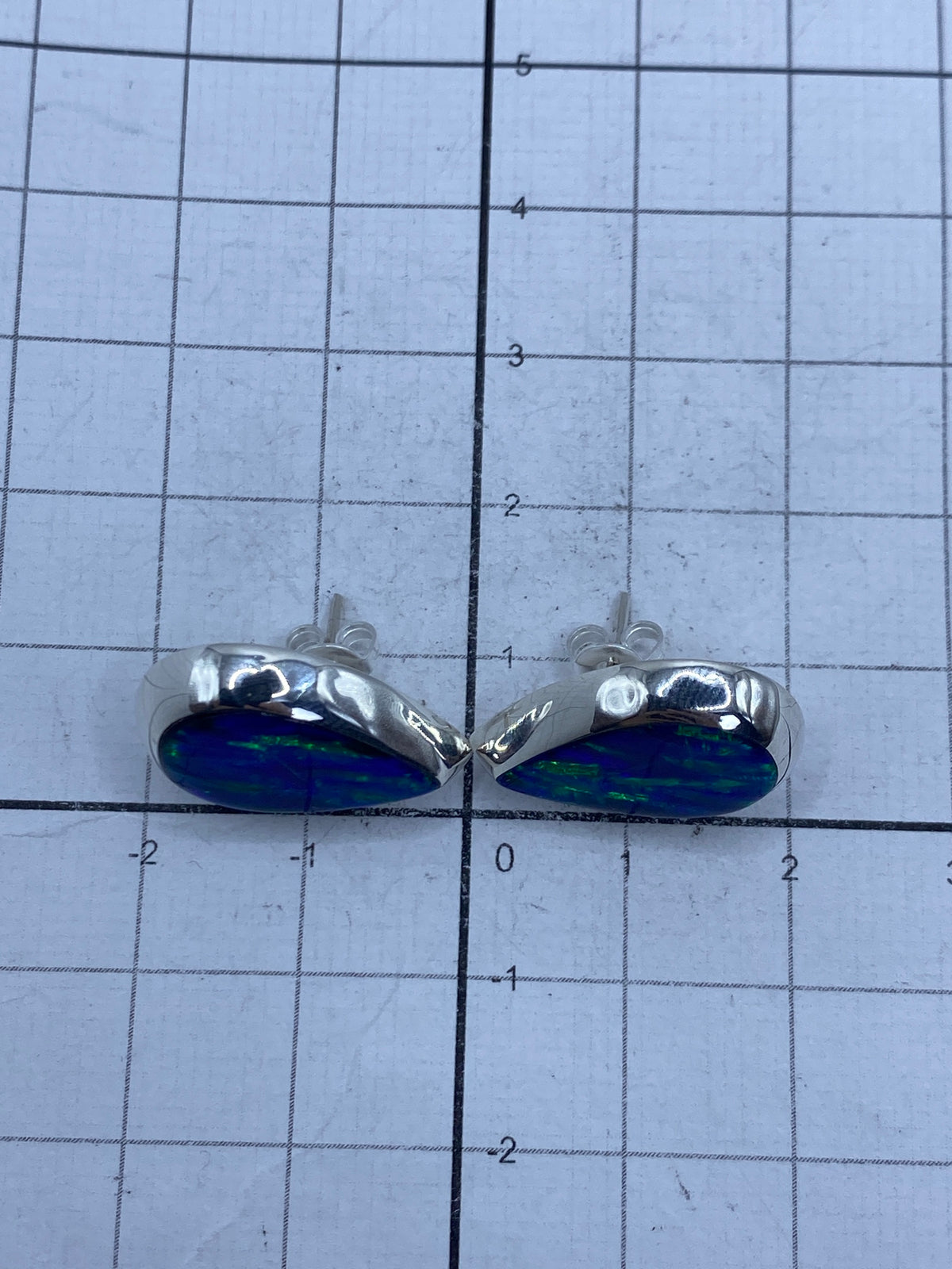 Aretes sobre fondo blanco mostrando el Quinto 925 en el reverso