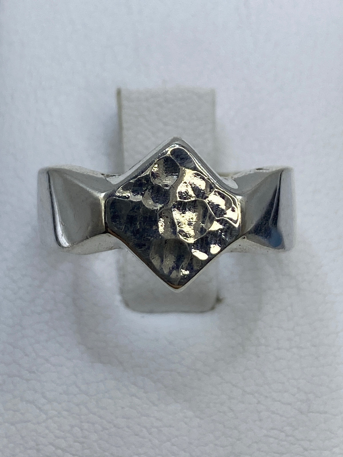 Anillo de plata 925 minimalista en la mano de una mujer, vista frontal del diseño pulido