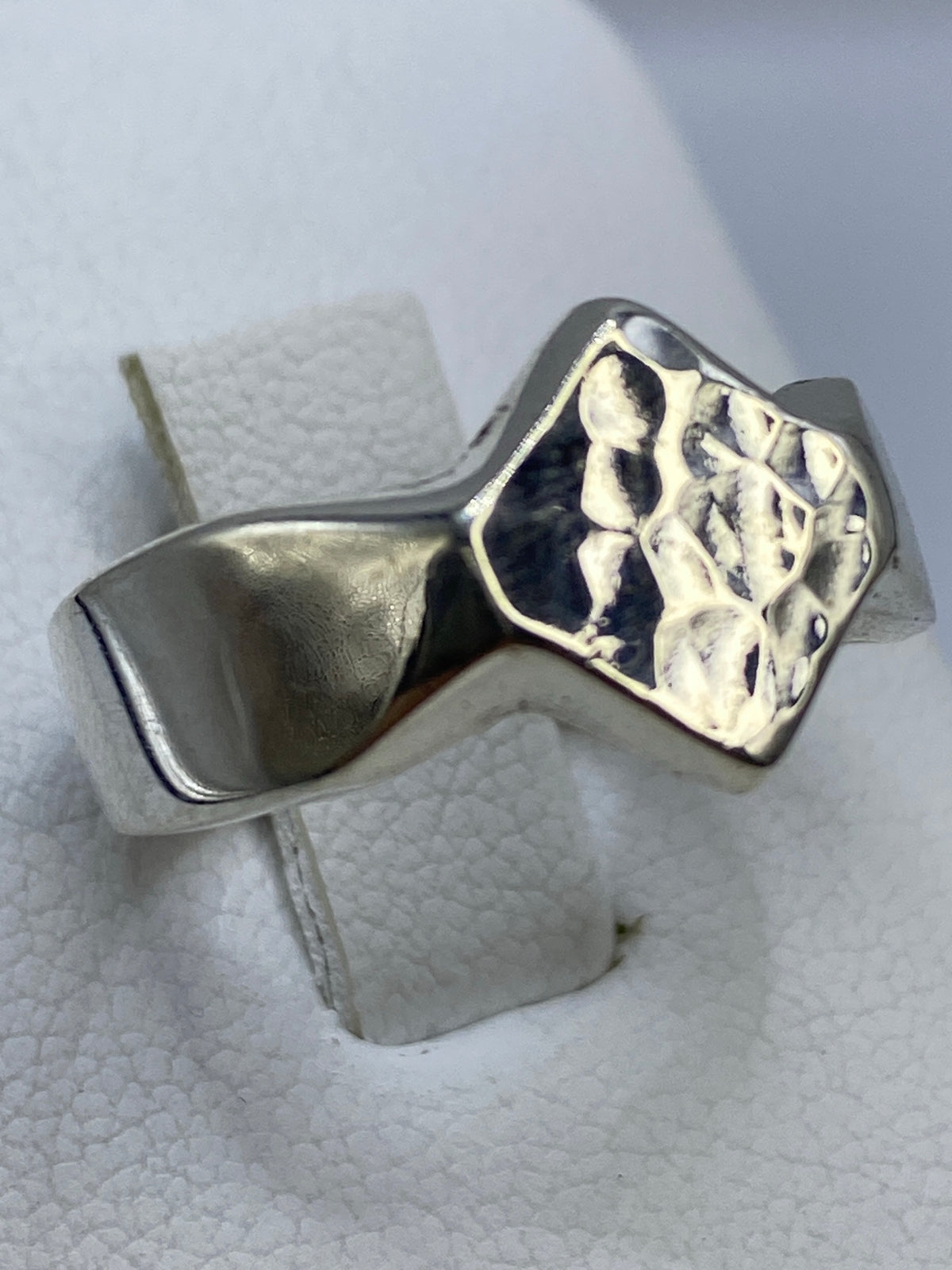 Detalle del costado del anillo mostrando el acabado pulido y los detalles laterales