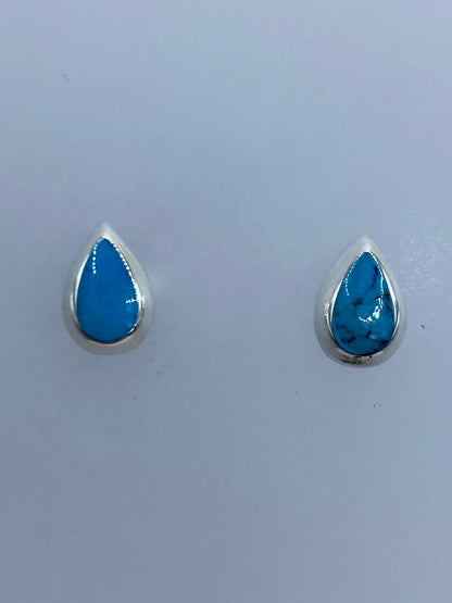 Par de aretes de turquesa con postes de plata, sobre regla mostrando 0.9 cm de largo