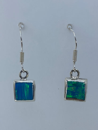 Detalle de los aretes mostrando el color verde olivo del ópalo y el gancho de plata