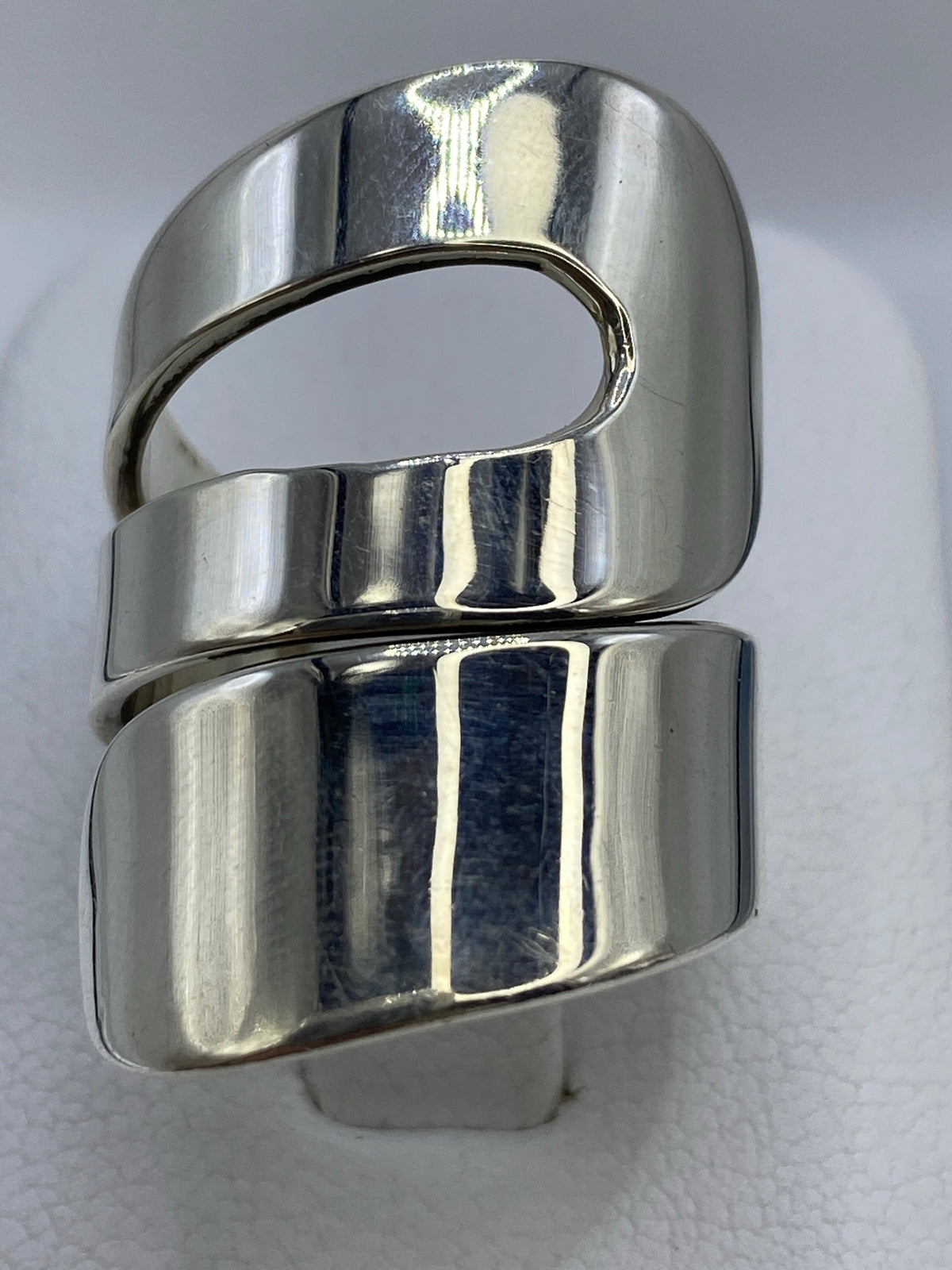 Anillo de plata calado con geometría escultórica en la mano de una mujer
