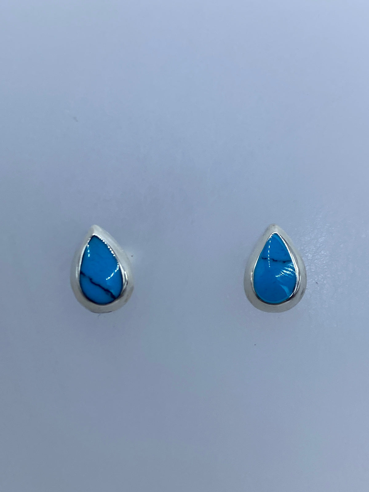 Par de aretes de plata con turquesa azul engastada, vista frontal