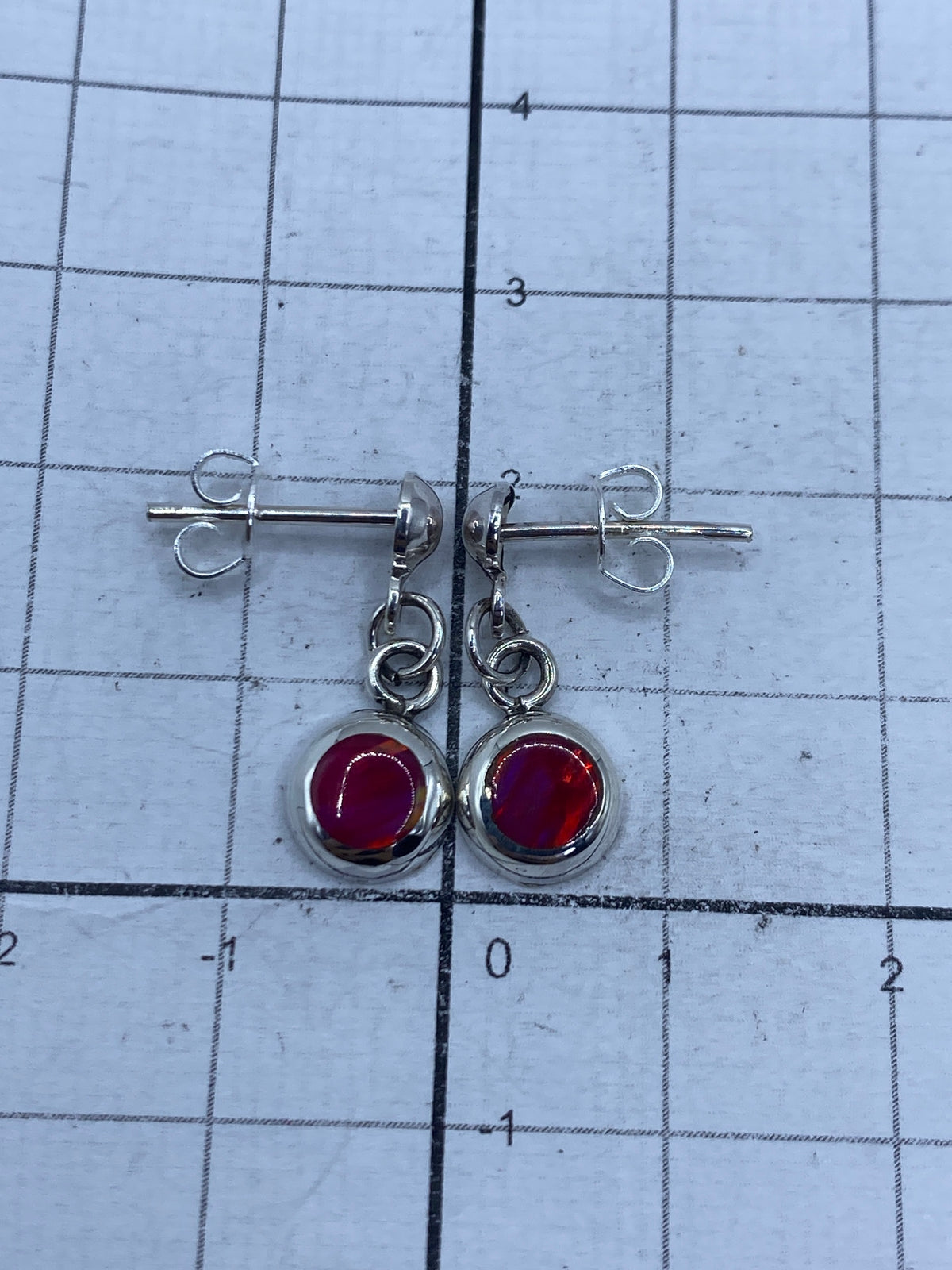 Aretes de ópalo rosa de Taxco en estuche sobre medidor de centímetros