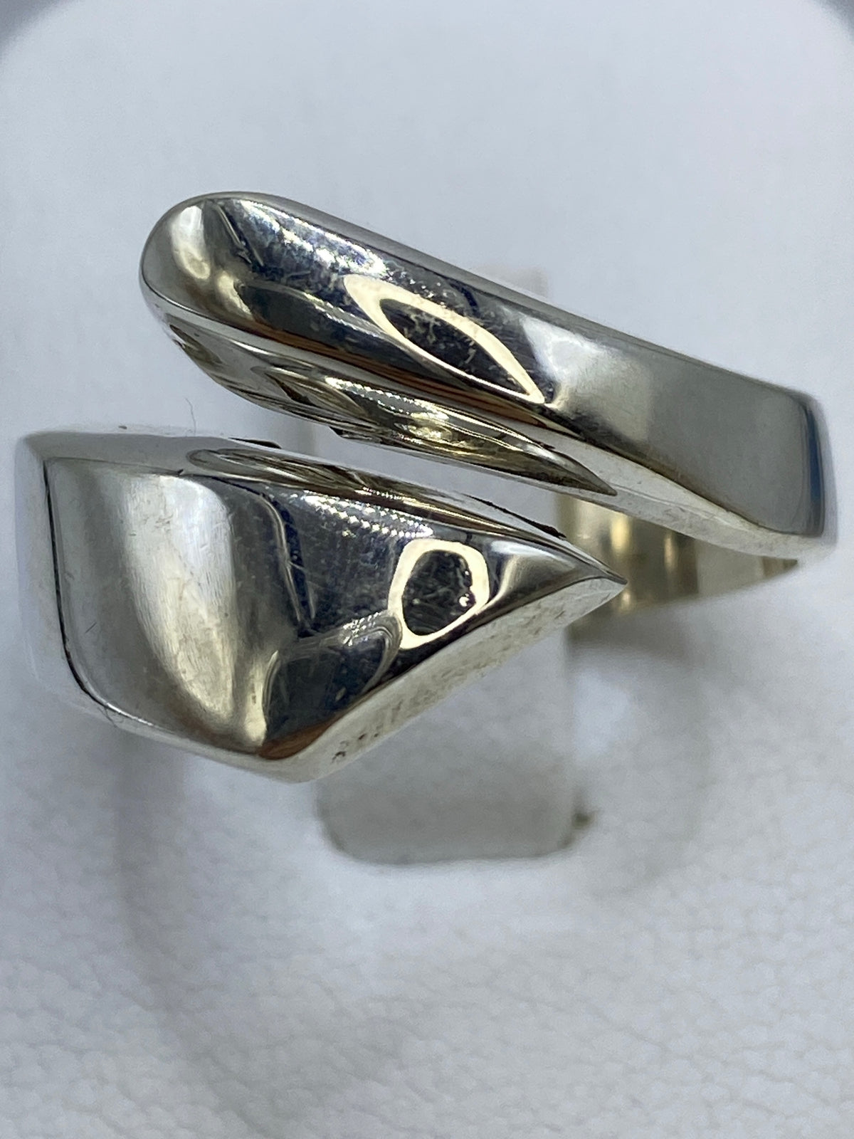 Anillo de plata repujado visto desde arriba sobre fondo blanco