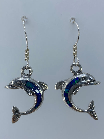 Aretes delfín de plata 925 con ópalo de fuego verde olivo, largos 3.8 cm, junto a una regla de medida