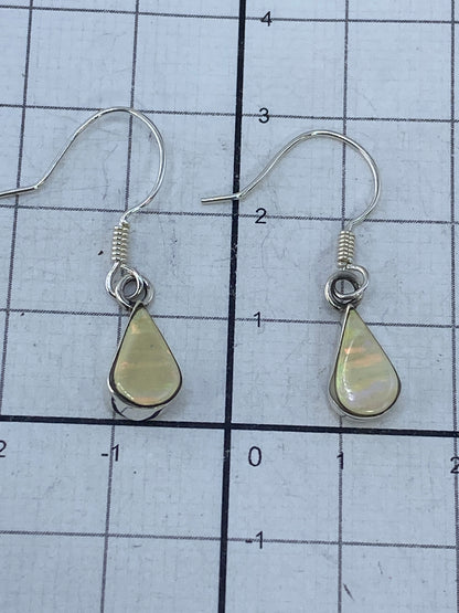 Aretes de plata con ópalo sobre fondo blanco, mostrando la pureza del metal y el Quinto