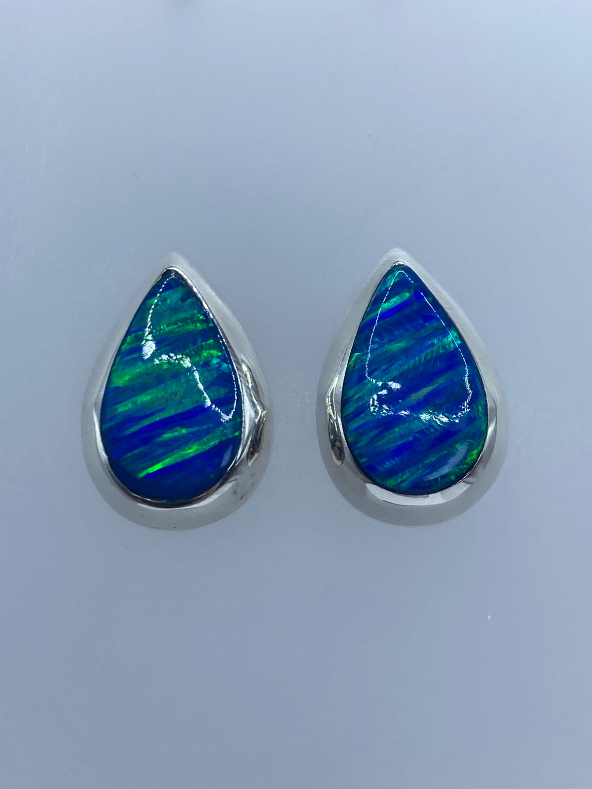 Detalle del ópalo de fuego azul con reflejos verdes en el engaste de plata