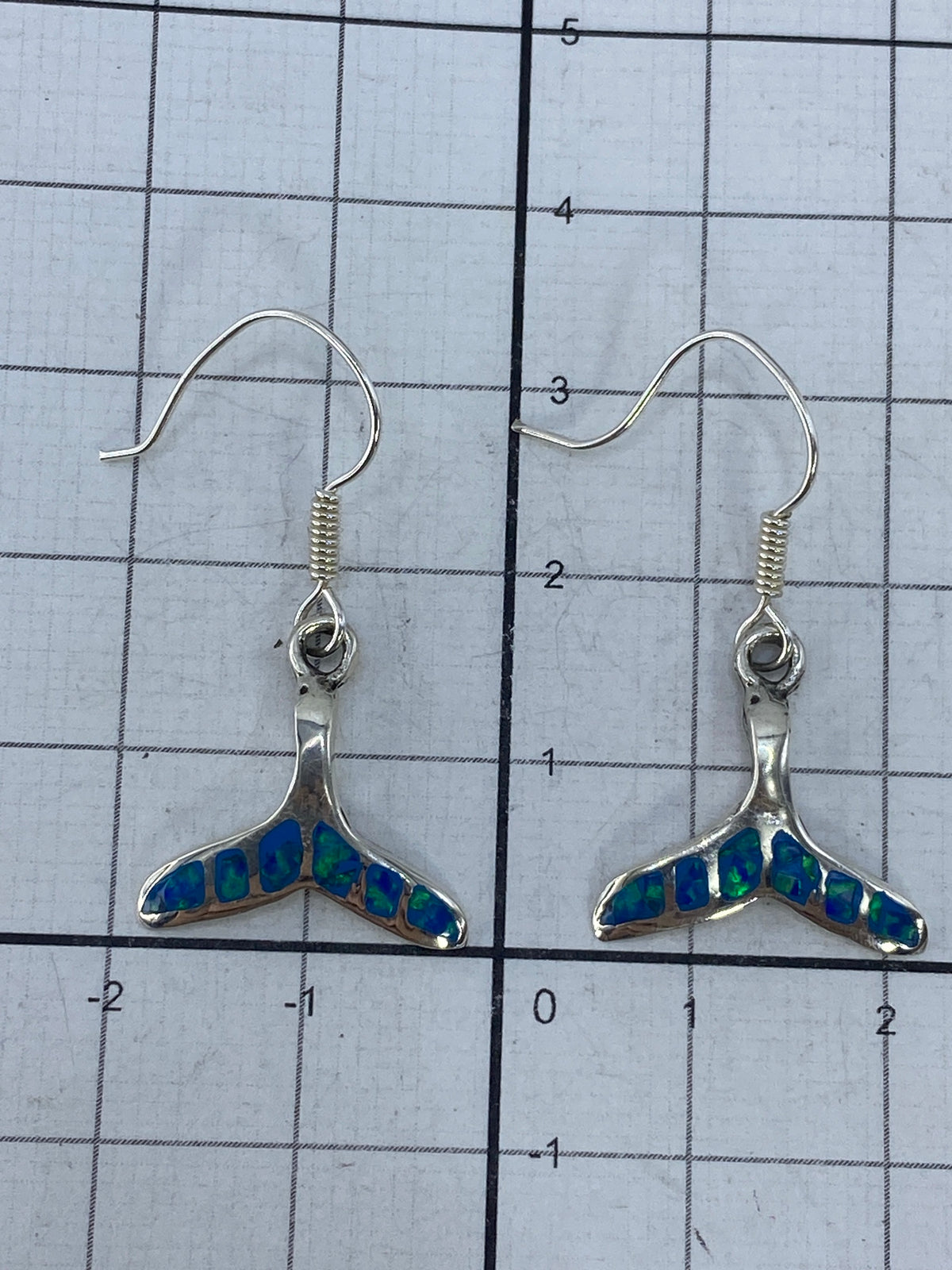 Aretes sobre fondo blanco con el Quinto 950 visible en el gancho
