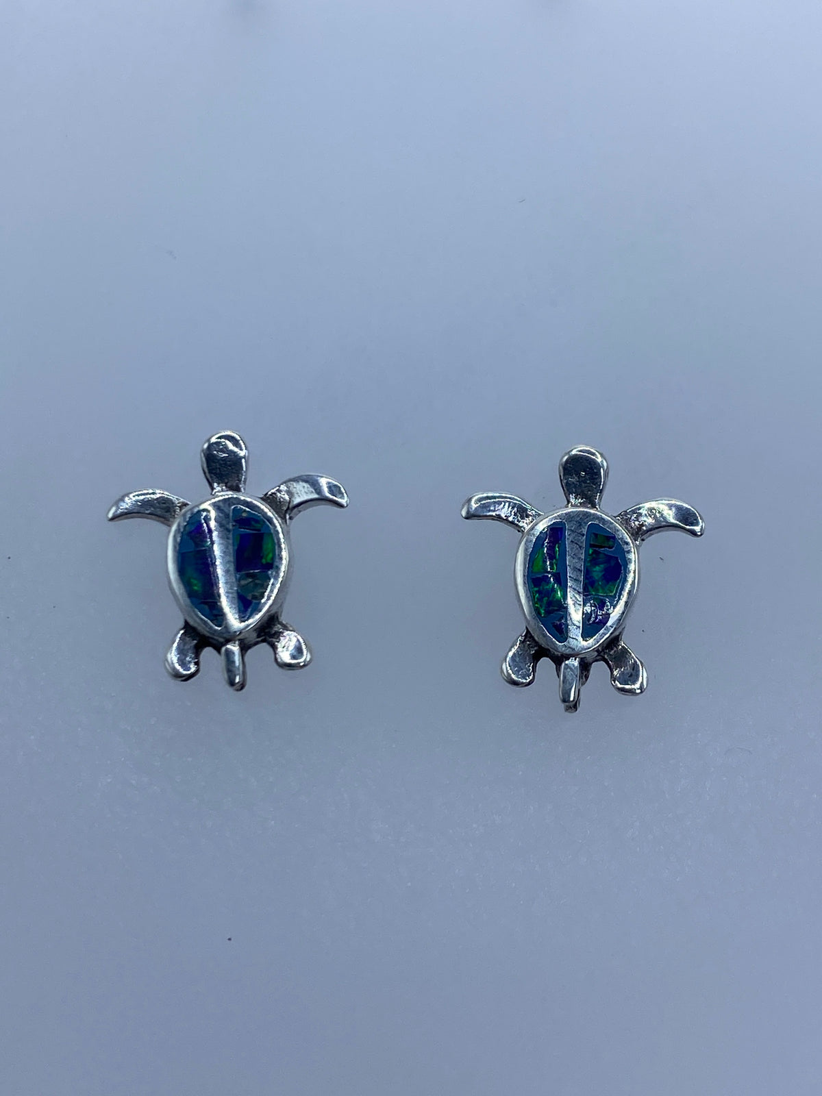 Detalle frontal del arete con ópalo azul engastado en la carapaza de la tortuga