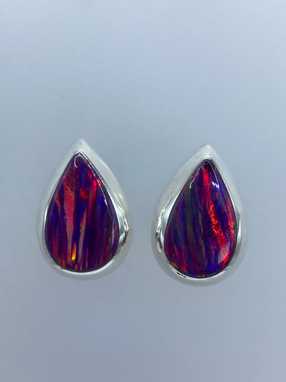 Par de aretes de plata 925 con ópalo de fuego morado, mostrando destellos anaranjados