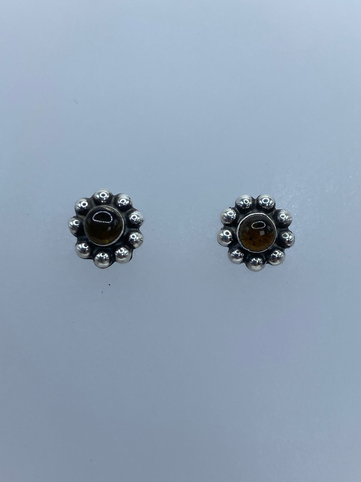 Detalle del engaste a mano del ámbar en la esfera de plata granulada