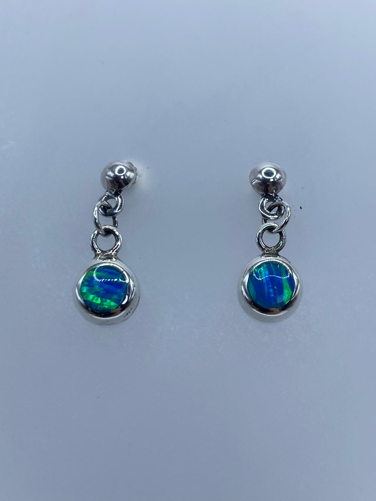 Detalle del ópalo azul con destellos verdes en aretes de plata 925
