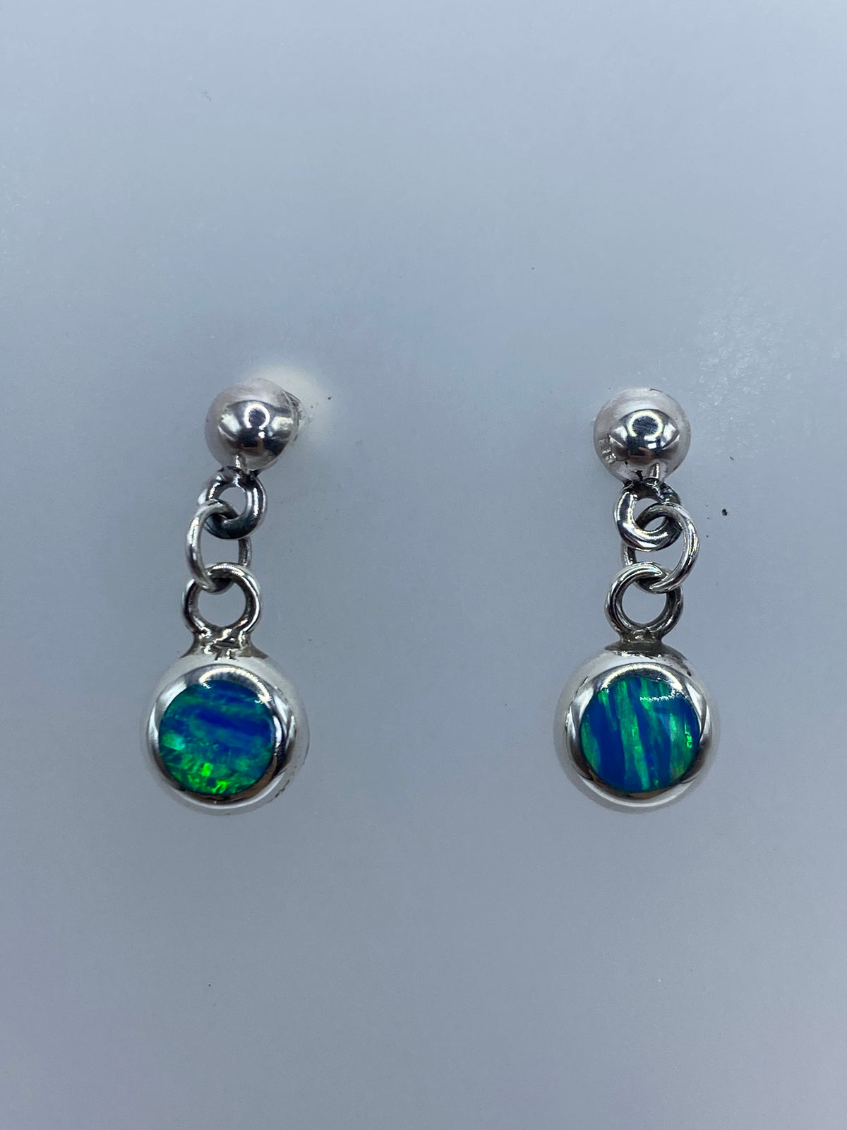 Aretes posados sobre regla mostrando medida de 2 cm