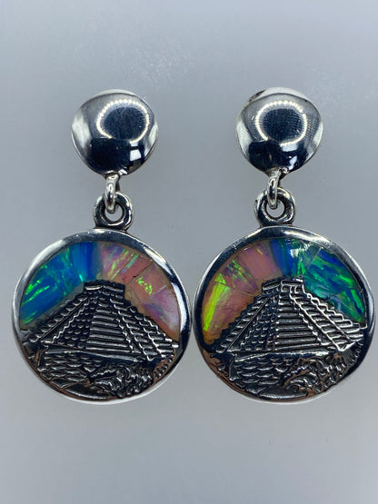 Aretes con diseño prehispánico de Chichén Itzá sobre escala de centímetros