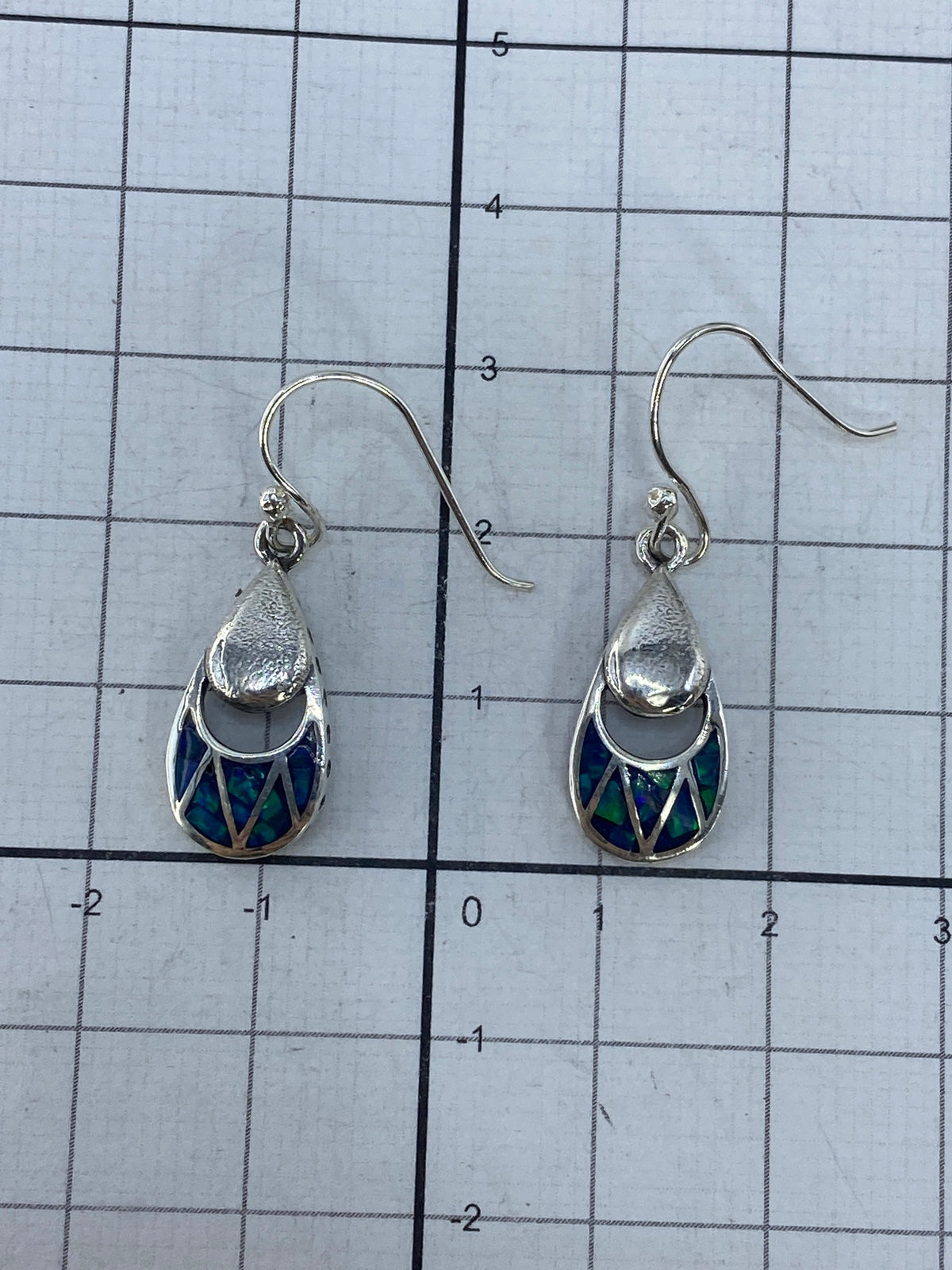 Aretes con luz natural resaltando los tonos verdes del ópalo de fuego