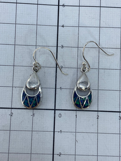 Aretes con luz natural resaltando los tonos verdes del ópalo de fuego