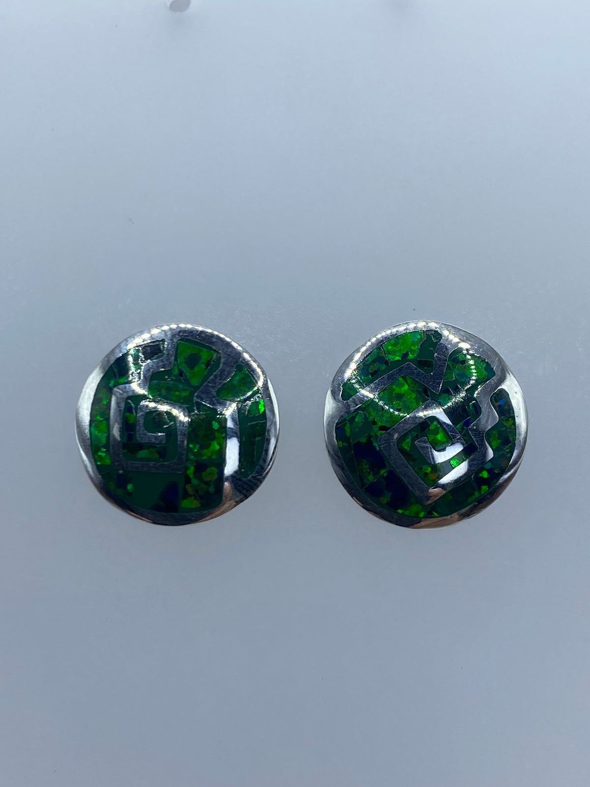Aretes de plata con ópalo de fuego verde, vista frontal de la piedra engastada