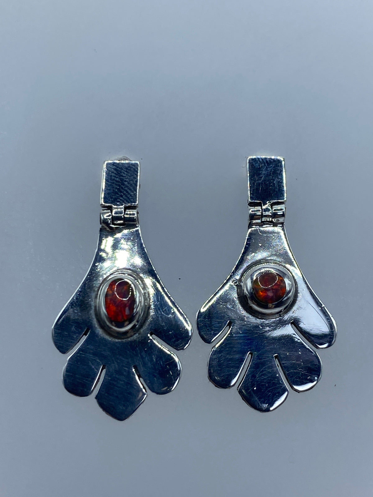 Detalle del arete mostrando el engaste artesanal del ópalo de fuego