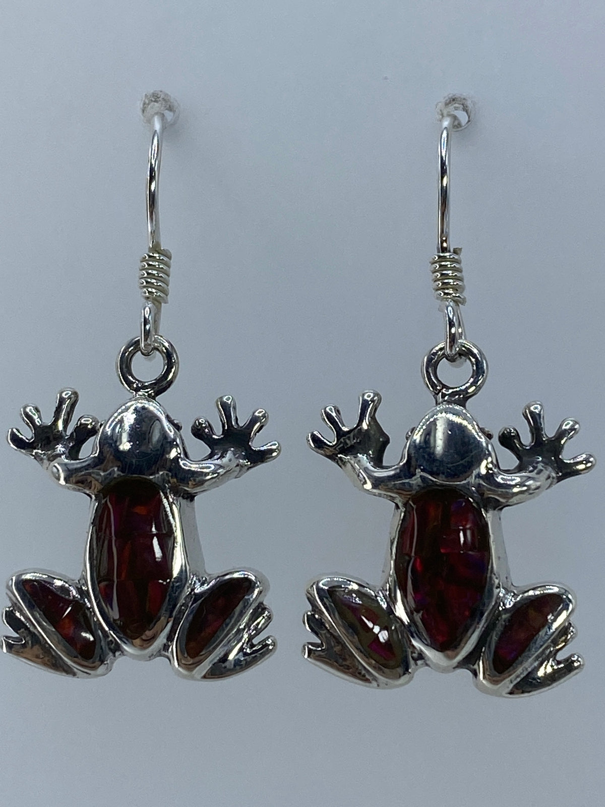 Aretes de ópalo multicolor colgando — vista frontal mostrando el juego de colores