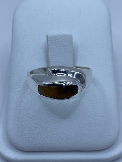 Anillo de plata 925 con Ojo de Tigre café engastado en el dedo medio de una mano