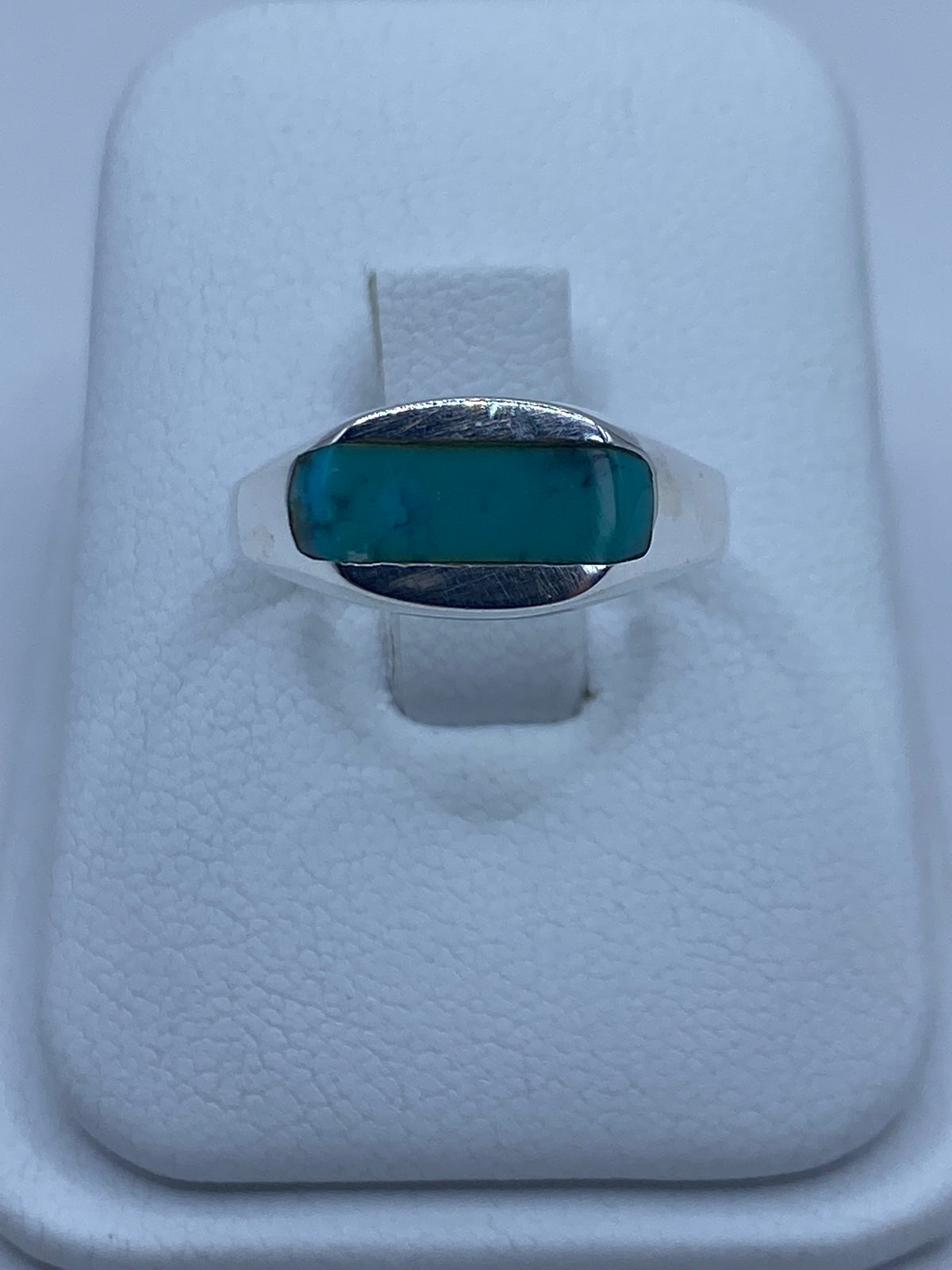 Anillo de plata 925 con turquesa azul cielo engastada, visto desde arriba sobre estuche blanco