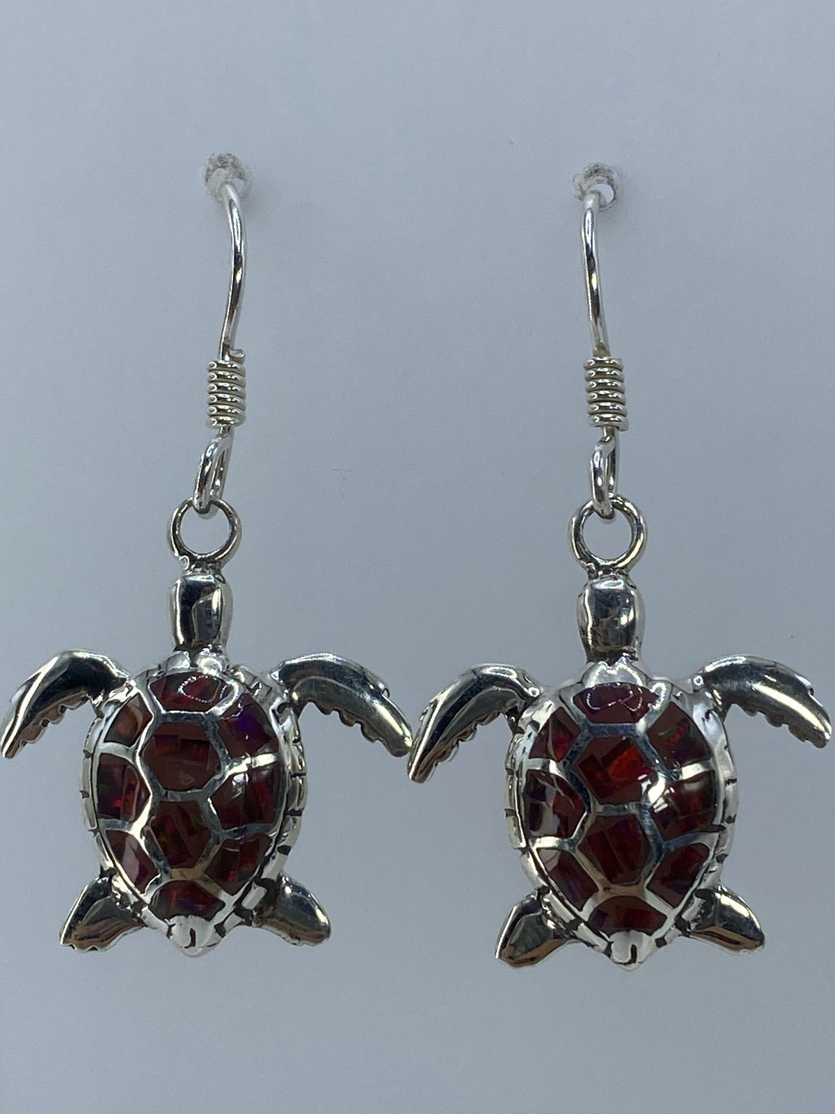 Aretes sobre medidor de centímetros mostrando el largo de 3.7 cm