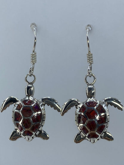 Aretes sobre medidor de centímetros mostrando el largo de 3.7 cm