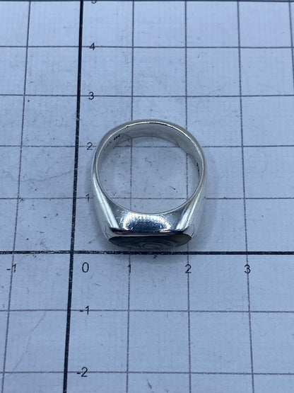 Anillo de plata con Quinto 925 y concha de abulón sobre fondo blanco