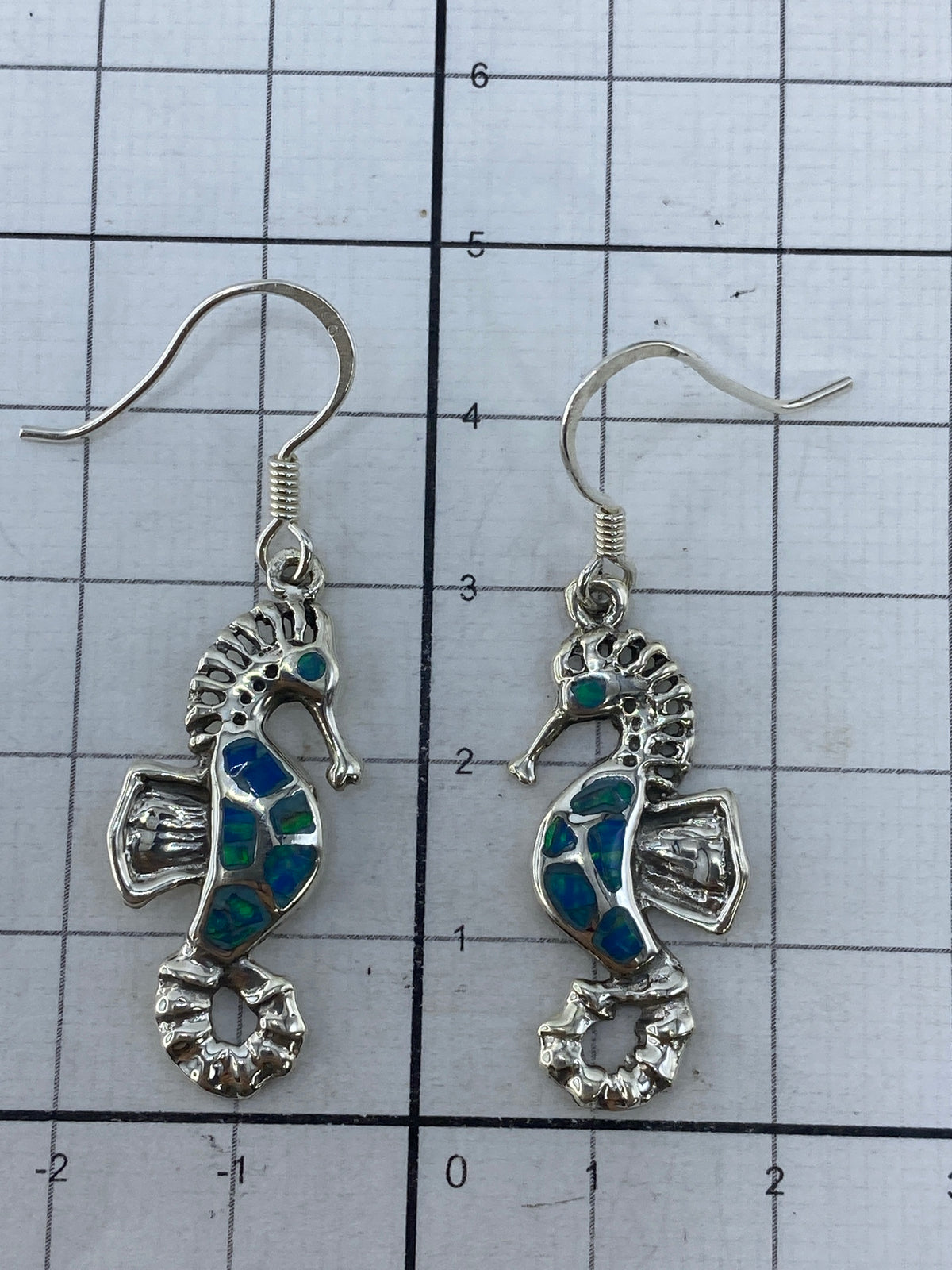 Aretes sobre fondo blanco con el Quinto 950 visible